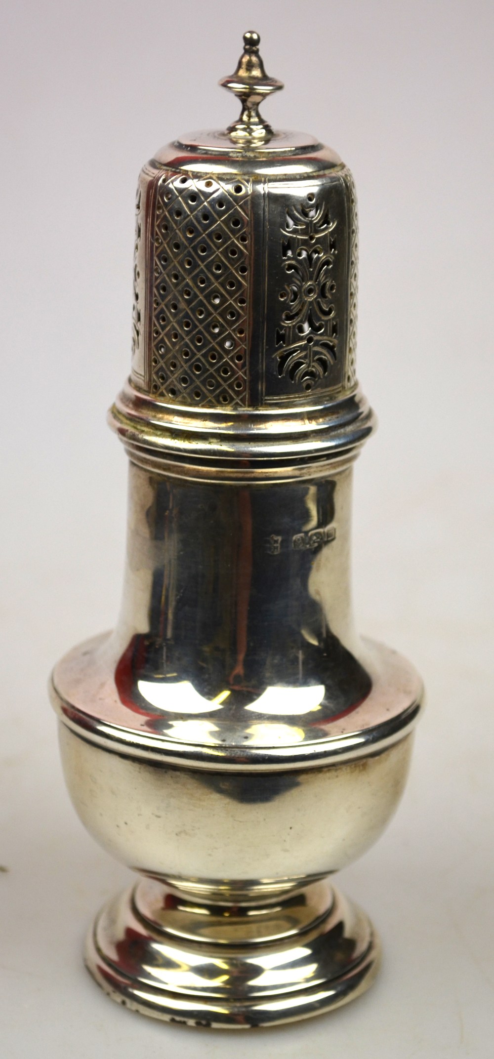 A silver baluster sugar caster with engraved and pierced top, on stemmed foot, Birmingham 1911, 7.