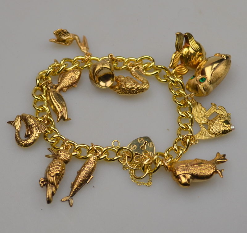 A 9ct yellow gold curb bracelet and padlock having twelve various charms attached, approx 34 g