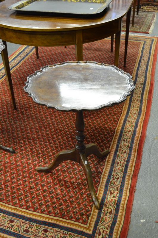 A George III mahogany tilt top tripod table, the circular top with moulded wavy edge on a turned