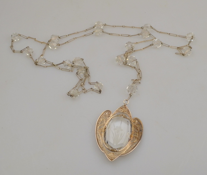 White metal filigree pendant having engraved paste centrepiece with iris suspended on matching chain