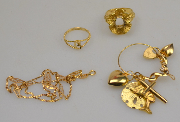 Various gold and yellow metal jewellery items including pendant with six charms attached, ring (