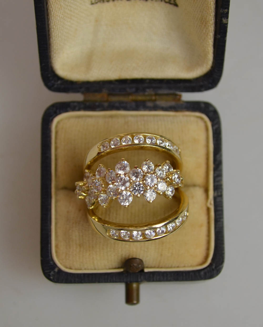 A set of three rings, one triple cluster and two half eternity, all set cubic zirconia, all