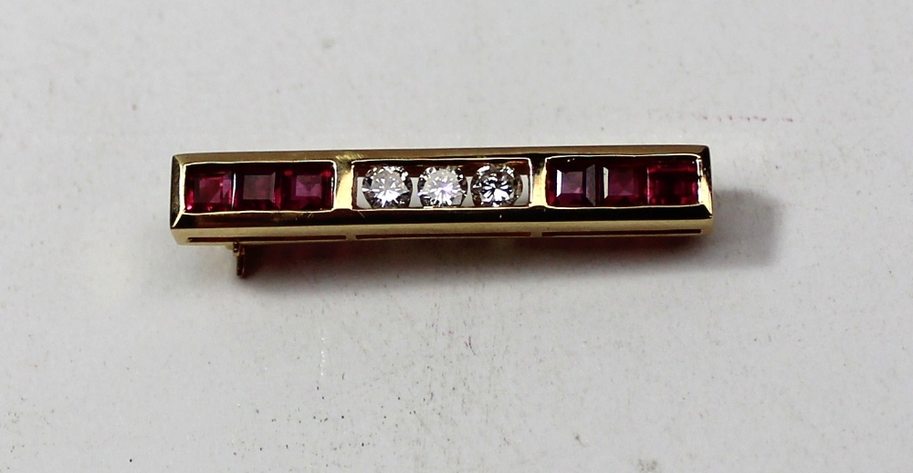 A diamond and ruby bar brooch set with six square rubies and three brilliant cut diamonds to an 18ct