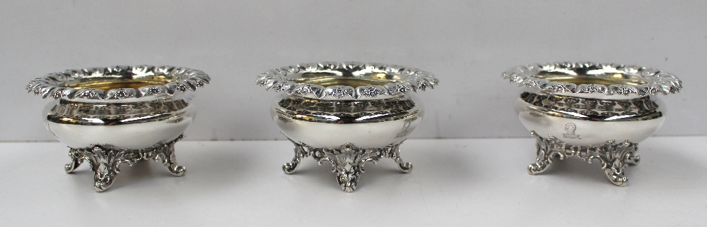 A set of three Victorian silver open table salts, the leaf and floral raised edge above a bulbous