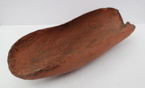 An Aboriginal treen new born baby cradle, painted in red ochre, 48 cm long