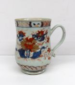 An 18th century Chinese baluster tankard decorated with flowers and leaves in reds, blues and golds,