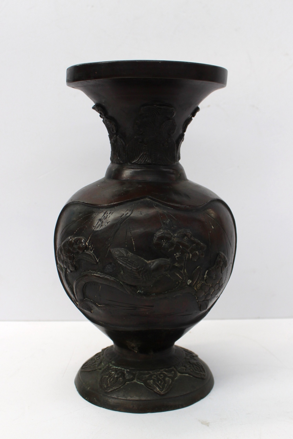 A Japanese bronze vase moulded with birds upon branches, 21.5 cm high