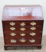 A George III mahogany bureau, the sloping fall with a pierced brass escutcheon enclosing a fitted