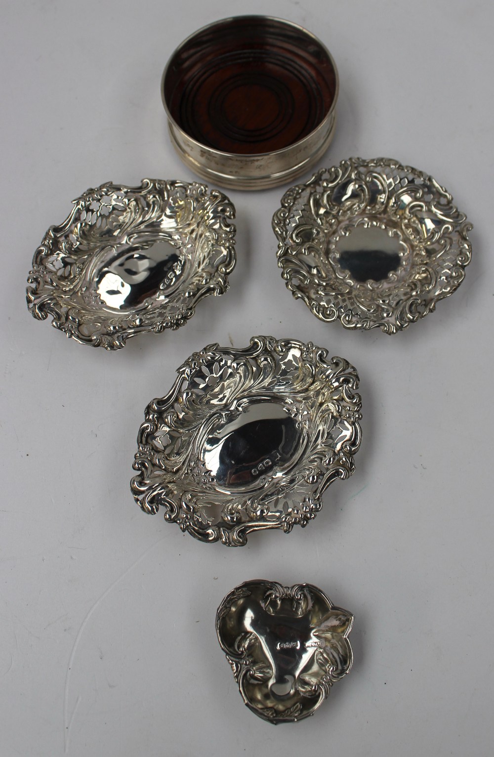 A pair of late Victorian silver bonbon dishes of pierced oval form decorated with scrolls and flower