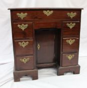 A George II mahogany kneehole desk, the moulded rectangular top above an arrangement of seven