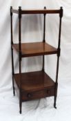 A Victorian mahogany whatnot, with three square shelves on ring turned columns, a base drawer,