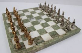 A 9ct yellow and white gold chess set of conventional form, with a green and white marble board,