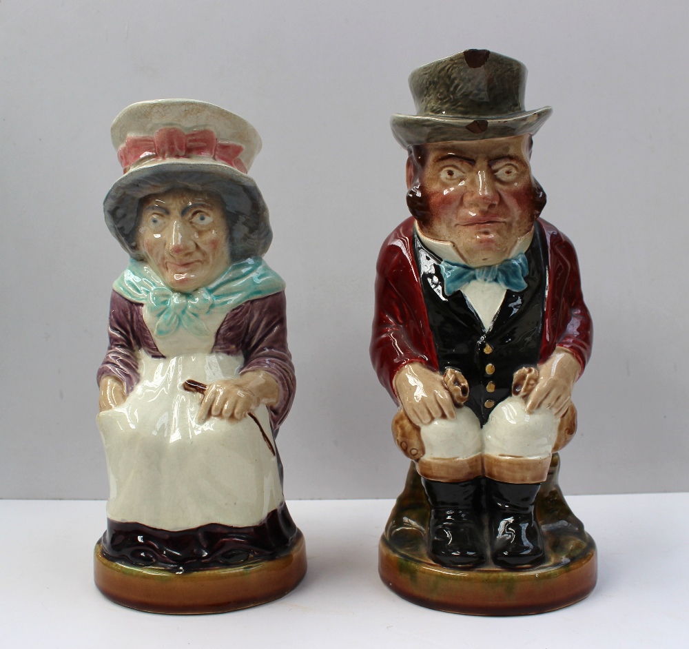 A pair of Sarreguemines toby jugs depicting a seated portly gentleman holding bags of money and a