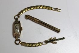A 9ct yellow gold toothpick with a sliding collar and engine turned cylinder, together with a 9ct