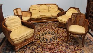An Art Deco style walnut beregere five piece suite, comprising a three seater settee, two arm chairs