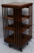 A 19th century mahogany revolving bookcase, the square top above  three shelves and slatted uprights