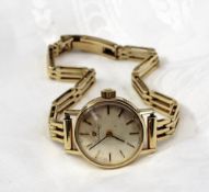 A ladies 14ct yellow gold Omega wristwatch the champagne dial with batons on a 14ct yellow gold