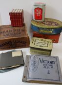 A collection of tins including a Cadbury Book tin, Victory Record Album, records etc