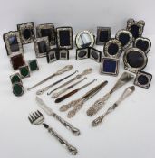 A collection of silver photograph frames, silver handled button hooks, etc