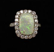 An opal and diamond dress ring the rectangular opal surrounded by twenty brilliant cut diamonds with