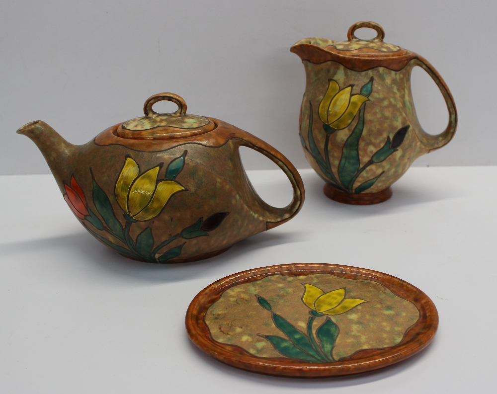 A Czechoslovakian teapot, teapot stand and hot water jug, decorated with tulips to a mottled ground,