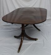 A Regency mahogany extending dining table, the oval top on twin pedestals with three splayed legs