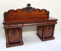 A Victorian mahogany pedestal sideboard, the raised back carved with leaves and scrolls, the