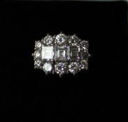 A diamond cluster ring set with three square baguette cut diamonds surrounded by twelve brilliant