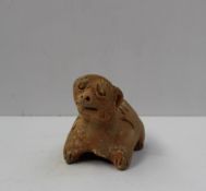 A Chinese red terracotta figure of a zodiac dog, traces of white pigment remaining, 8.5 cm high,