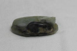 A Chinese jade carving of a recumbent cat with a mouse in its jaws, 5.5cm long