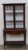 An Edwardian mahogany display cabinet with a moulded cornice above a pair of glazed doors, the base
