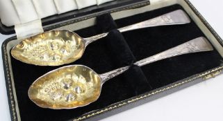 A pair of George III silver berry spoons, the gilt bowls embossed with fruit and leaves, the handles