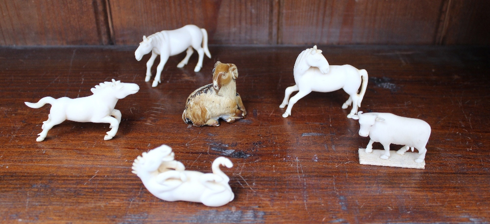 A set of four Chinese carved ivory studies of horses, together with an ivory oxen and a model of a