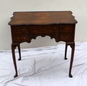A 19th century continental marquetry decorated low boy, the shaped top above an arrangement of three