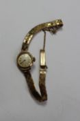 A ladies 9ct yellow gold Majex wristwatch  the silvered dial with batons on a 9ct yellow gold strap