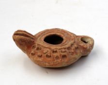 A Chinese terracotta oil lamp of squat cylindrical form, 9 cm long