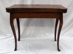 A 19th century oak card table with rounded corners and a shallow apron on cabriole legs and