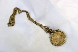 An Edward VII gold sovereign dated 1910 in a 9ct yellow gold slip mount on a yellow metal chain,