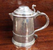 A George II silver lidded tankard with a ribbed cylindrical body on a spreading foot, London,
