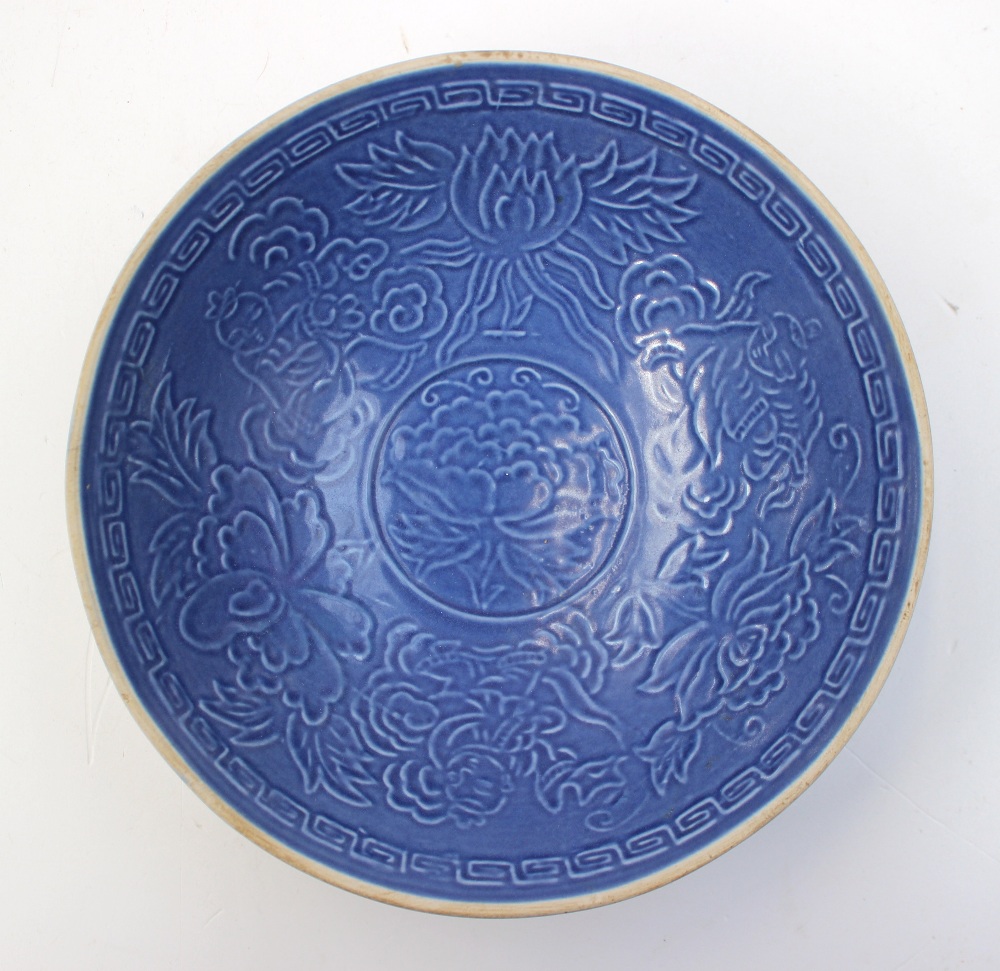 A Chinese sky blue glazed pottery bowl, moulded interior design showing foliage and floral relief,