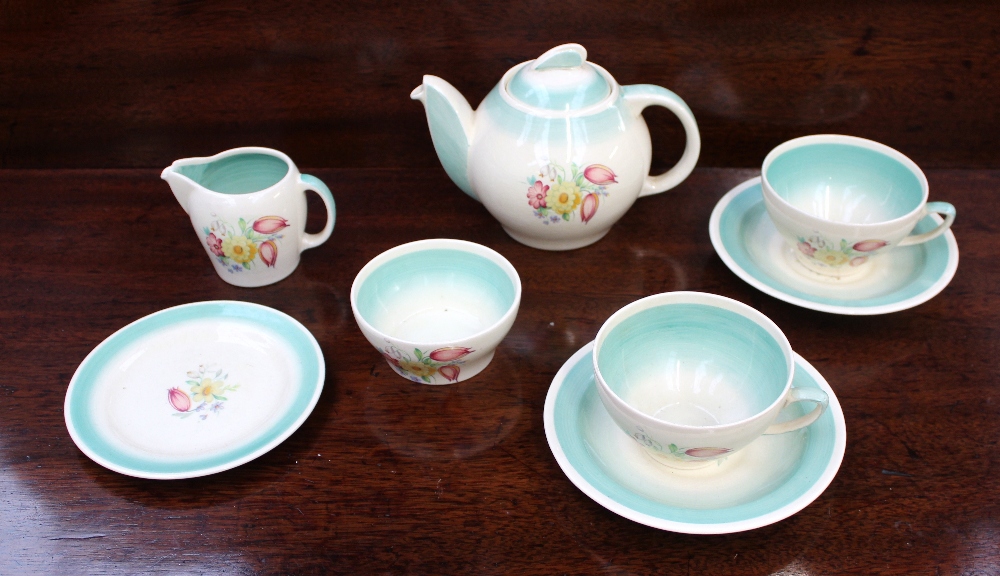 A Susie Cooper part tea set printed with flower heads and leaves to a green border, including a