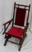 An American child`s rocking chair, with a spindle back, arms and rails, 73 cm high