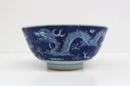 A Chinese porcelain blue and white footed bowl, decorated with dragons chasing pearls, to a cloud