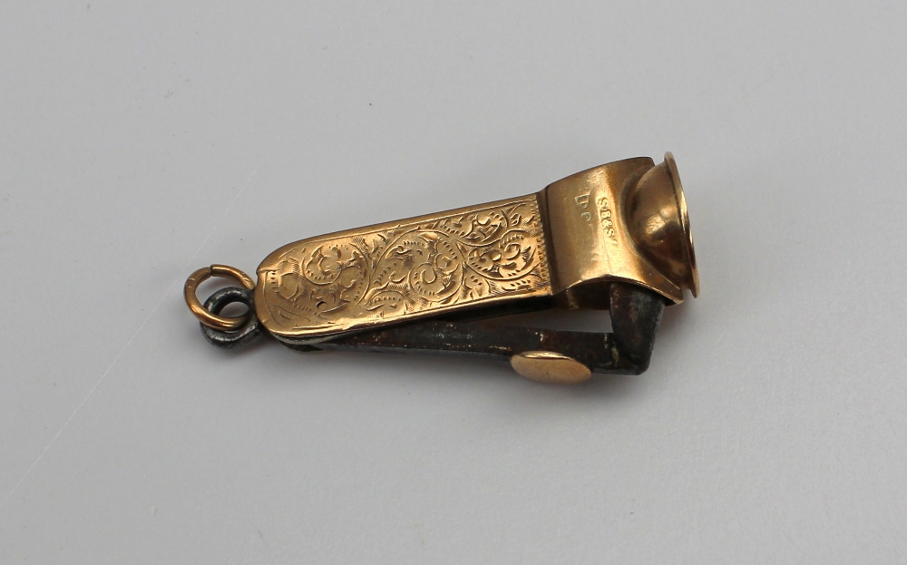 A 9ct yellow gold cigar cutter, with scroll and flower decoration