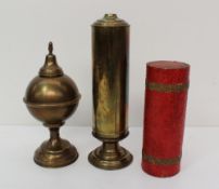 A brass two section pedestal tube trick, with tooled card cover, together with a brass globe