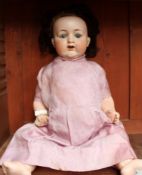 An Armand Marseille Bisque head doll, with fixed eyes, open mouth and a tooth, to a composition