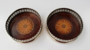 A pair of mahogany and white metal mounted bottle coasters, with a beaded rim with pierced