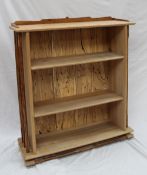A contemporary oak bookcase, the rectangular top with three quarter gallery and shaped pillars and