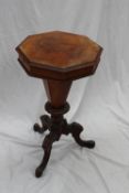 A Victorian walnut work table, the hinged octagonal top enclosing a fitted interior and central