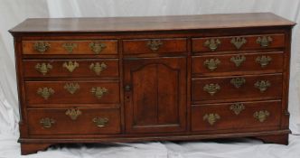 An 18th century oak North Wales dresser base, the rectangular top with canted corners above a